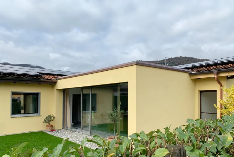 Magliaso MS: casa gialla a un piano con grandi porte vetrate sul giardino