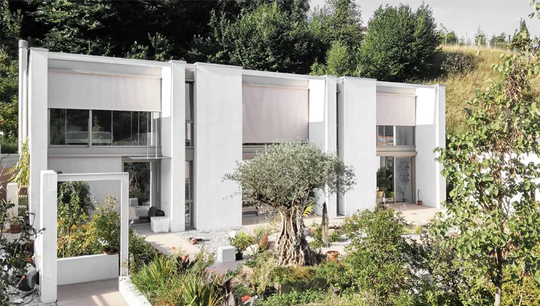 La casa di Pianezzo KG: volumi bianchi, grandi vetrate e un ulivo nel giardino